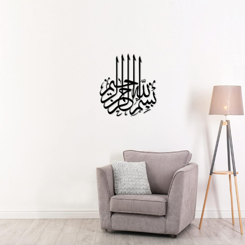 Gray armchair with a decorative pillow in a room with a lamp and Arabic calligraphy wall decal.